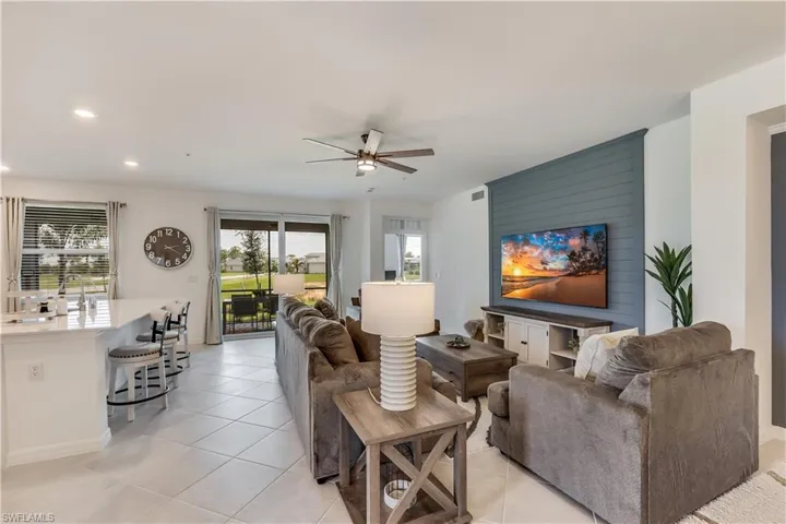 Living room featuring sink, ceiling fan, and light tile floors