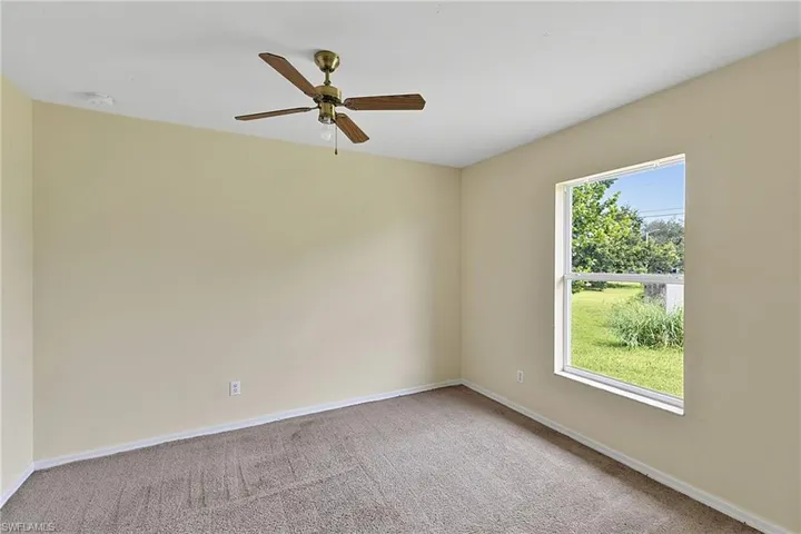 Carpeted room with neutral wall color and white trim