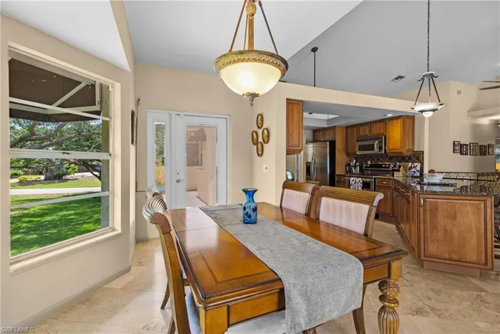 Tiled dining area with lofted ceiling