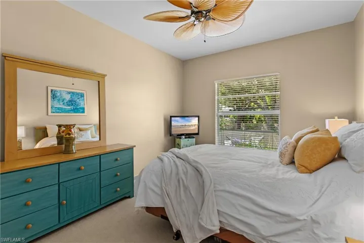 Bedroom 2 with ceiling fan and light colored carpet