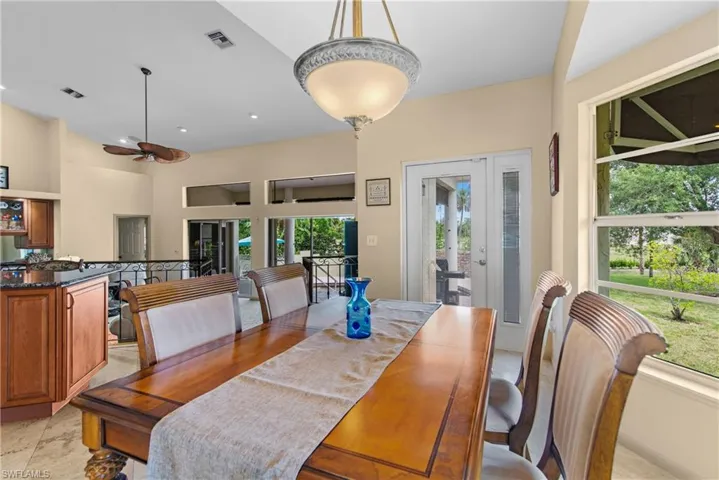 Tiled dining room with french doors, lofted ceiling, and ceiling fan