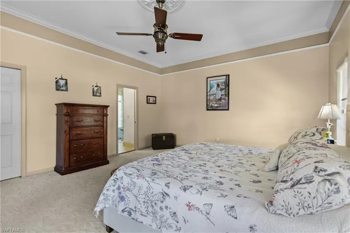 Main Bedroom with ceiling fan, carpet floors, and crown molding