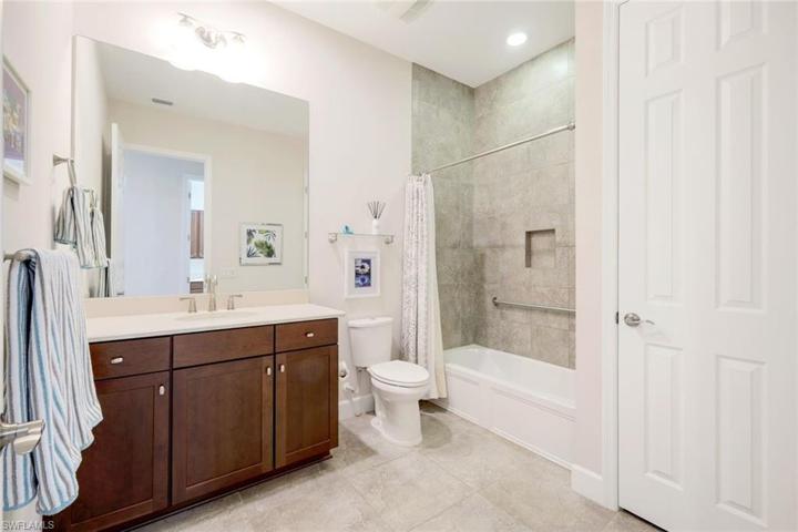 Large guest bath with tub/shower combination, with tile to ceiling.