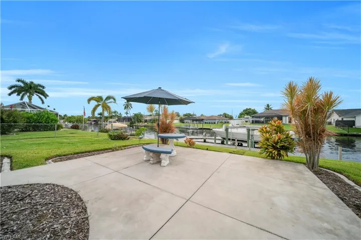 View of patio / terrace with boat lift, a boat dock, a water view, and a residential view