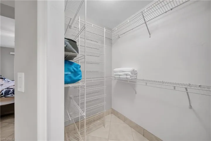 Walk in closet with light tile patterned floors