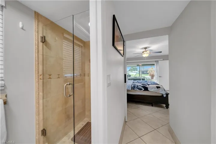 Ensuite bathroom featuring light tile patterned floors and a shower stall