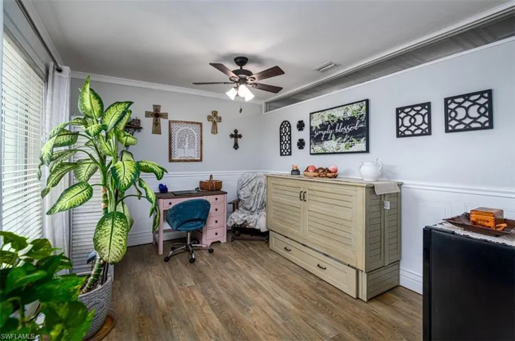Office space featuring ceiling fan, dark hardwood / wood-style floors, and ornamental molding