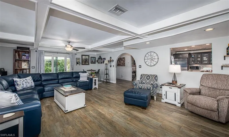 Living room featuring ceiling fan, beamed ceiling, dark wood-type flooring, and coffered ceiling