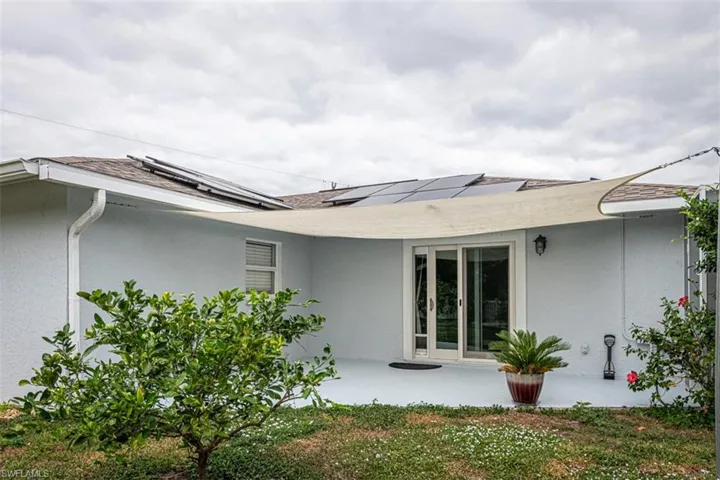 Rear view of property with a patio and solar panels
