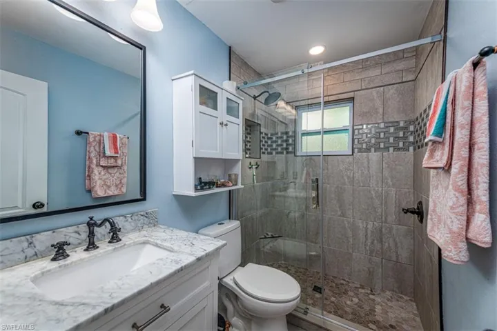 Bathroom with vanity, toilet, and walk in shower