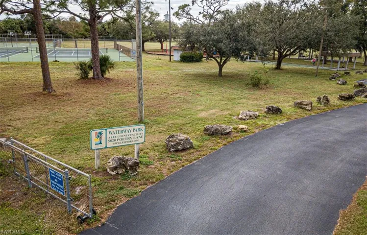 View of community with a yard and tennis court