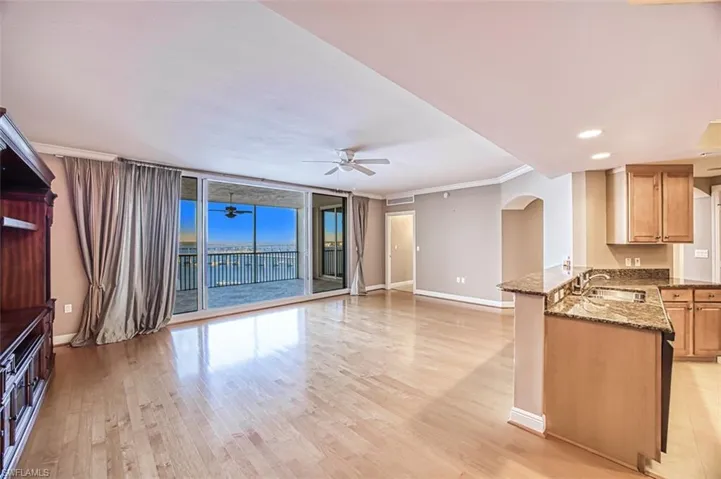 Unfurnished living room featuring ceiling fan, light hardwood / wood-style floors, crown molding, and sink