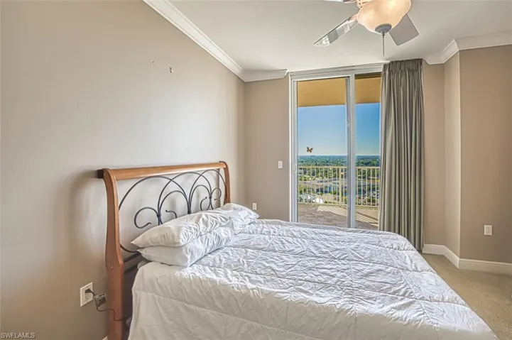 Carpeted bedroom featuring ceiling fan, ornamental molding, and access to outside