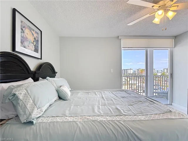 Bedroom featuring access to exterior, a textured ceiling, and a ceiling fan