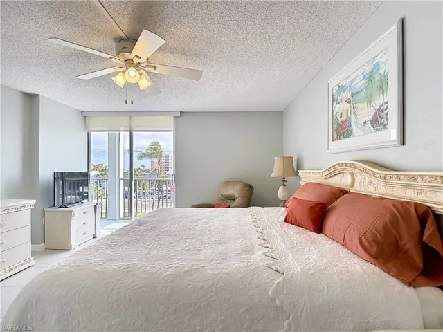 Bedroom featuring a textured ceiling, a ceiling fan, and access to exterior