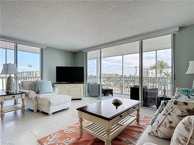 Living room featuring floor to ceiling windows, a textured ceiling, and light tile patterned floors