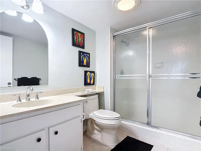 Full bathroom with vanity, a shower stall, and light tile patterned floors