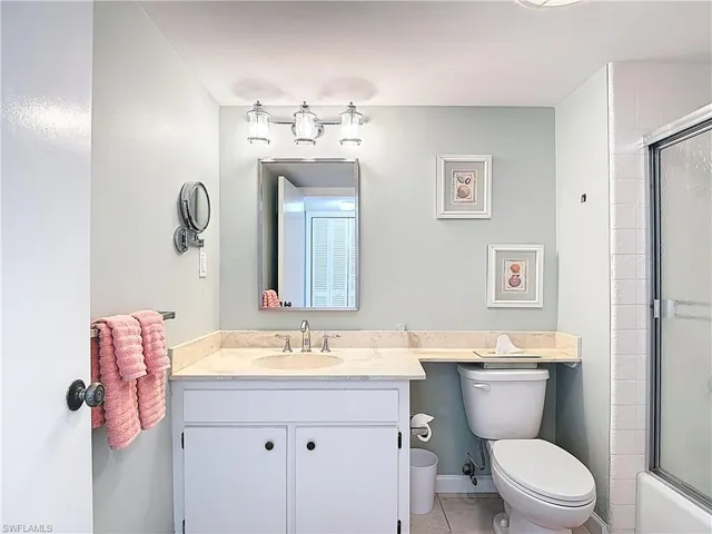 Full bathroom with vanity, combined bath / shower with glass door, and light tile patterned flooring