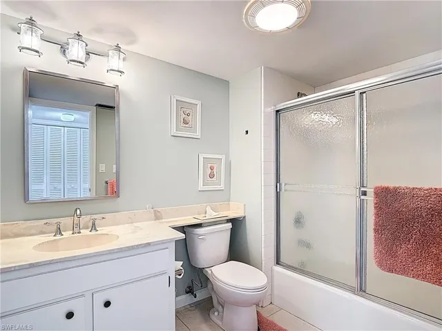 Full bathroom with vanity, combined bath / shower with glass door, and light tile patterned flooring