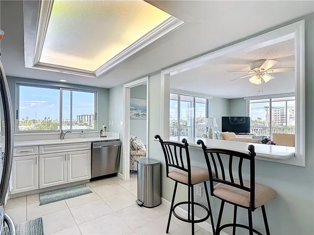Kitchen with white cabinets, stainless steel appliances, a ceiling fan, light tile patterned floors, and a textured ceiling