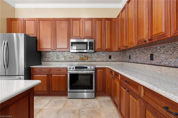 Kitchen featuring plenty of wood cabinetry and quartz countertops.