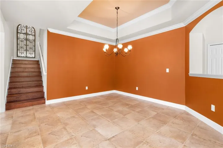 Separate dining area or flex room with chandelier and crown molding.