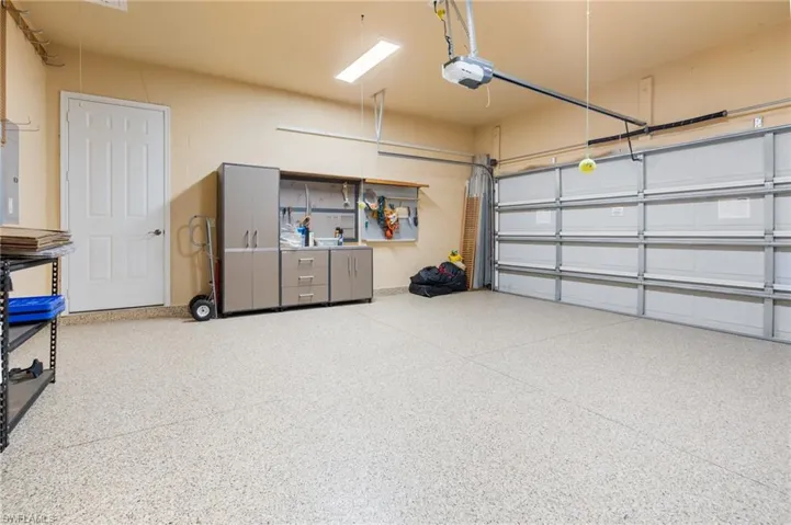 Garage with a garage door opener & refinished floor.