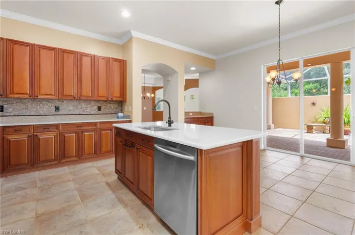 Kitchen with a quartz center island with sink, looking through sliding doors onto courtyard.