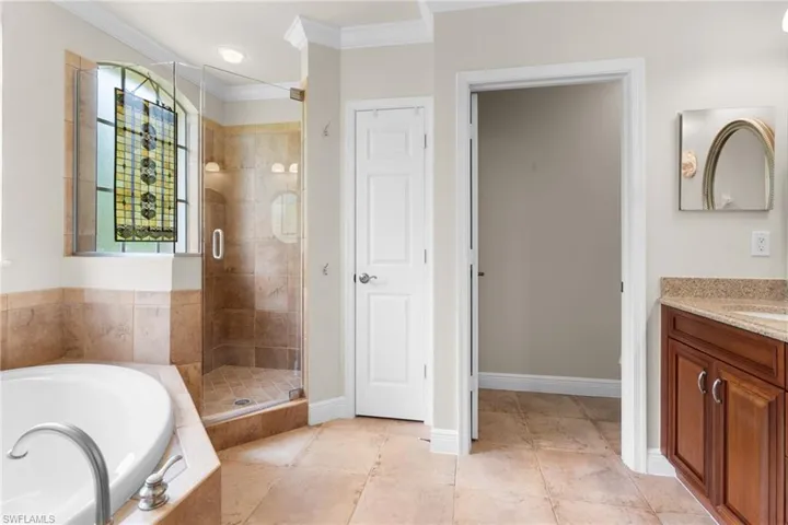 Bathroom featuring tile & tile floors, vanity, and separate shower and tub.