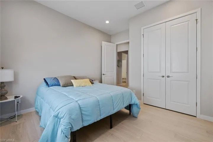 Bedroom featuring light wood-style flooring, recessed lighting, visible vents, baseboards, and a closet