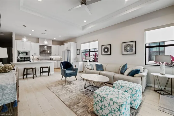 Living area featuring light wood-type flooring, a tray ceiling, and ornamental molding