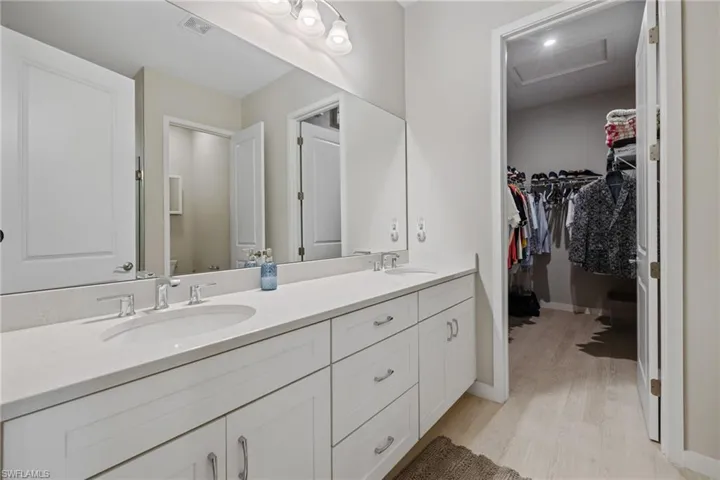 Full bath featuring wood finished floors, a sink, toilet, and double vanity