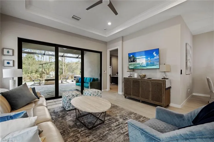 Living room with a tray ceiling, recessed lighting, visible vents, light wood-type flooring, and baseboards