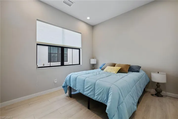Bedroom featuring baseboards, visible vents, wood finished floors, and recessed lighting