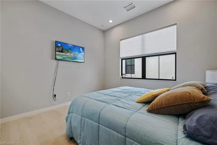 Bedroom with recessed lighting, visible vents, light wood finished floors, and baseboards