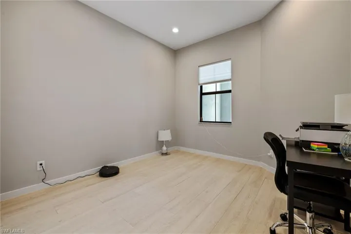 Office with light wood finished floors, baseboards, and recessed lighting