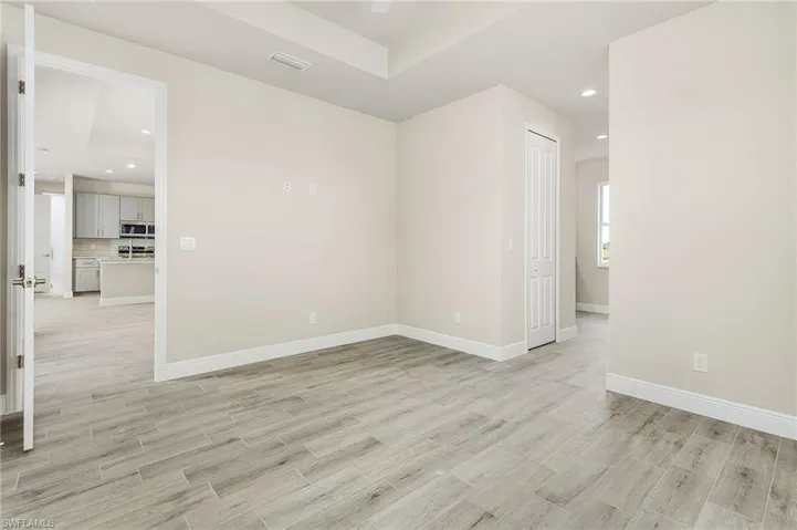 Unfurnished room with light hardwood / wood-style floors and a raised ceiling
