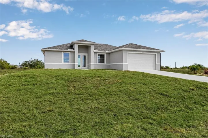 View of front of home with a garage and a front lawn