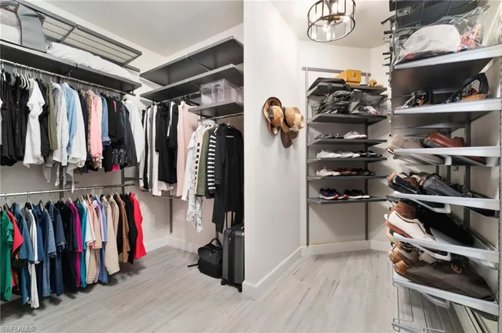 The master bedroom closet features a custom build-out, complemented by elegant custom light fixtures