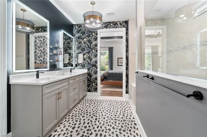 The master bathroom features elegant lighted mirrors for added ambiance