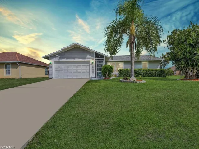 Single-story residence featuring a two-car garage, concrete driveway, and a screened front entry