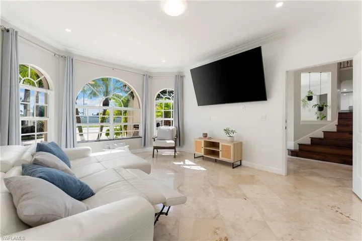 Living room with crown molding, stairway, and recessed lighting