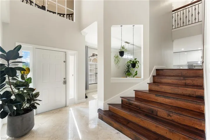 Entrance foyer featuring a towering ceiling, stairs, and healthy amount of natural light
