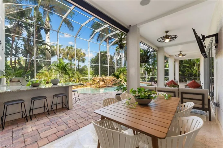 Sunroom featuring a patio area, outdoor dining space, and ceiling fan