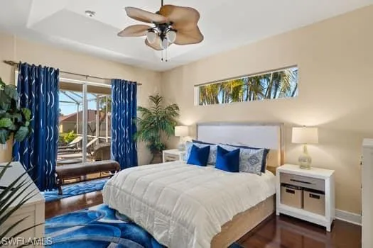Bedroom with ceiling fan, access to exterior, and dark hardwood / wood-style flooring