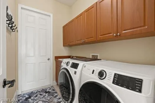 Laundry room featuring cabinets and washing machine and dryer
