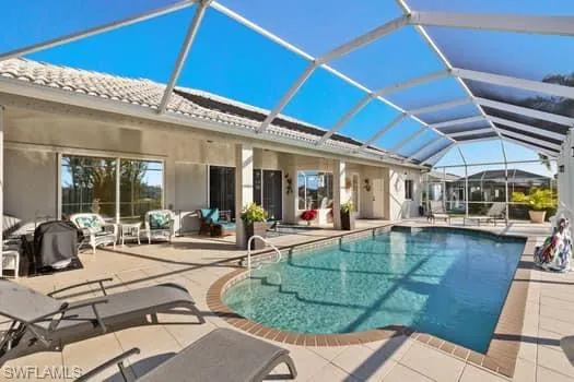 View of pool with a lanai and a patio