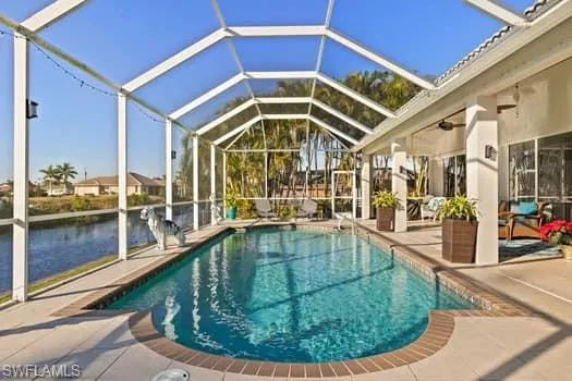 View of swimming pool with a water view, a lanai, and a patio area