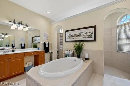 Bathroom featuring tile patterned floors, vanity, and independent shower and bath