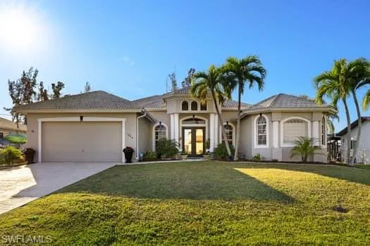 View of front of home featuring a garage, a front lawn, and french doors